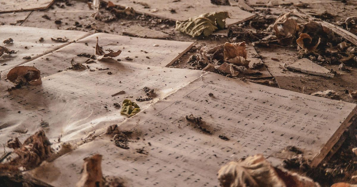 Abandoned hymn books strewn with dirt and leaves